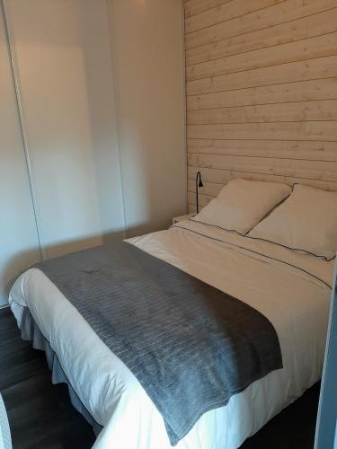 une chambre avec un grand lit avec une tête de lit en bois dans l'établissement Le Royal Parc - Appartement au calme au coeur de Bénodet, à Bénodet
