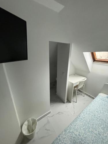 a bedroom with a bed and a table and a television at Casa El Viso in Madrid