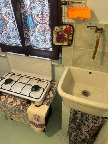 a bathroom with a sink and a stove at Cottage Gole Alcantara D’amore in Graniti