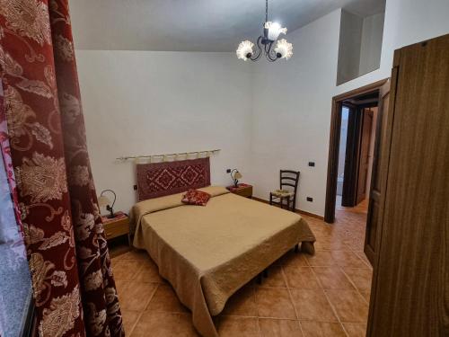 a bedroom with a bed and a chandelier at Casa Vacanze Sa Petra Ruja La Caletta di Siniscola in Siniscola