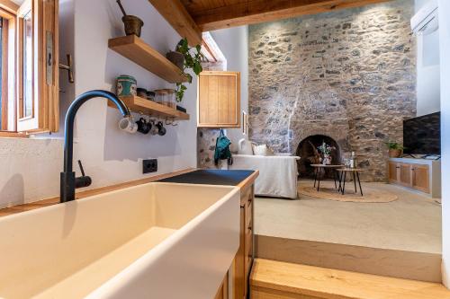 a kitchen with a sink and a stone wall at Olivetta ,Traditional stone house in Kos Town