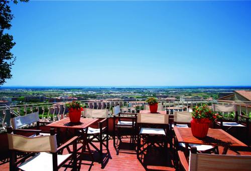 a patio area with tables, chairs and umbrellas at Hotel Tarconte in Tarquinia