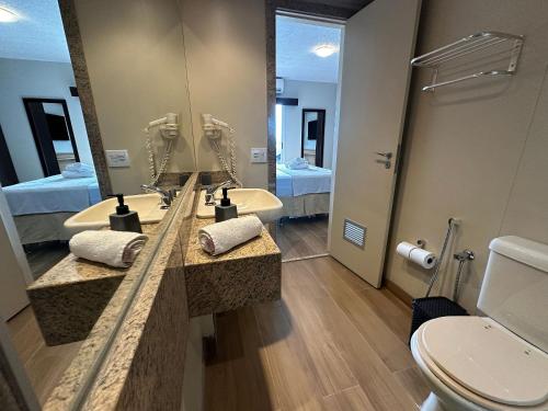 łazienka z umywalką, toaletą i lustrem w obiekcie Loft de alto padrão e vista para o mar | MASD309 w mieście Macaé