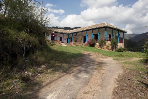 a house on a hill next to a dirt road at Casa Campestre SUANOGA in Pesca