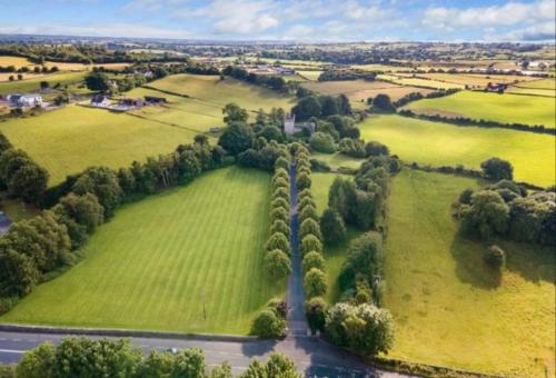 an aerial view of a field with trees and a river at Moyvannan Castle on 7 Acres in Roscommon