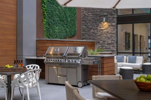 an outdoor patio with a grill and tables and chairs at Element Colorado Springs Downtown in Colorado Springs