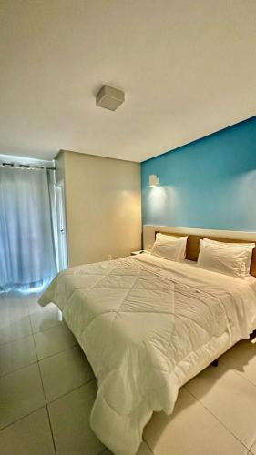 a large white bed in a room with a blue wall at Hotel Master in Jequié