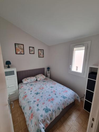 une chambre avec un lit et une fenêtre dans l'établissement Le Ti'Bo- Appart T3 proche plage, à Narbonne-Plage