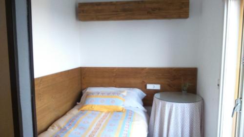 a bed with a wooden headboard in a room at La Masia in Sant Pere Pescador