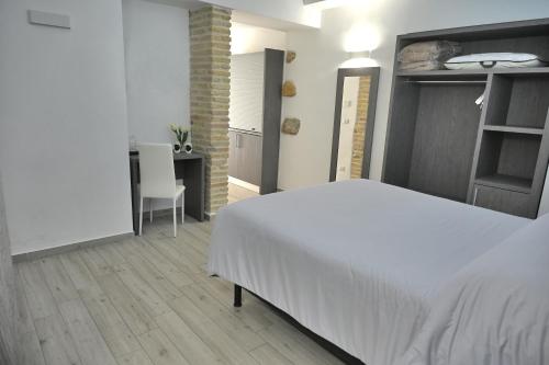 a bedroom with a white bed and a desk at B&B Diana in Piazza Armerina