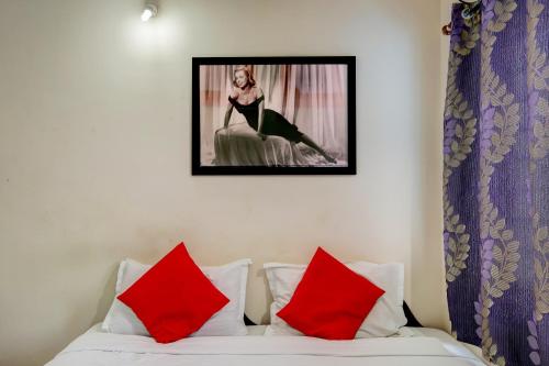 a picture of a woman sitting on a bed with red pillows at Hotel O HOTEL UTSAV PALACE in Bengaluru