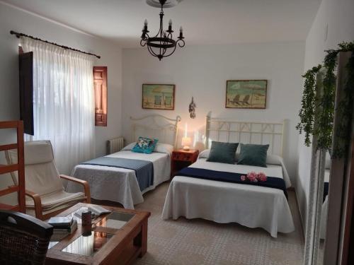 a bedroom with two beds and a chair and a table at Apartamentos Oreña in Oreña