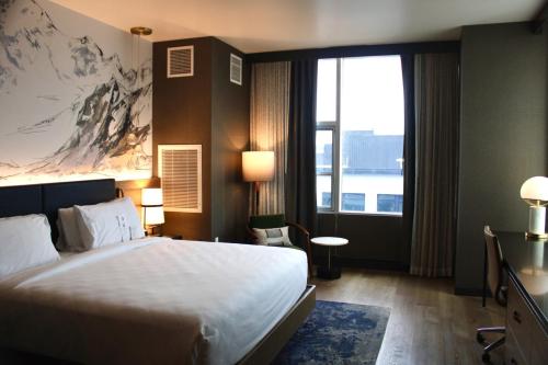 a hotel room with a bed and a large window at Hotel Indigo Vancouver Dwtn - Portland Area by IHG in Vancouver