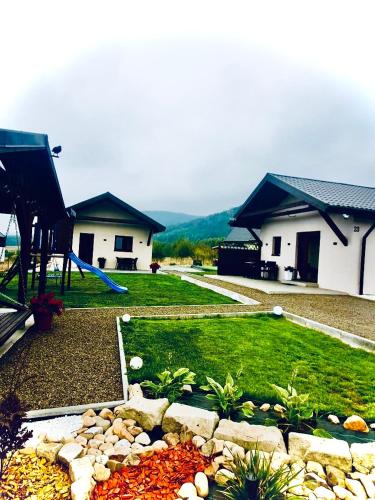 a backyard with a playground with a slide and a house at Domki z Widokiem in Wünschelburg