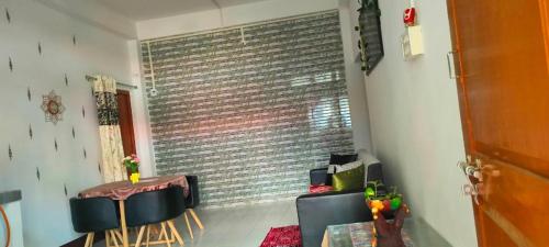 a room with a table and chairs and a brick wall at Primrose Homestay in Guwahati