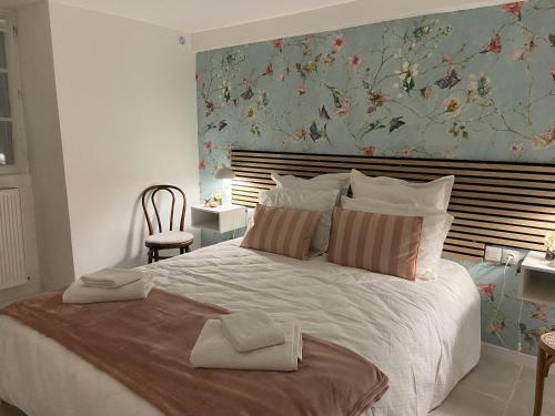 a bedroom with a large bed with a floral wallpaper at La petite maison in Solesmes