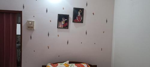 a white wall with pictures on it with a couch at Primrose Homestay in Guwahati