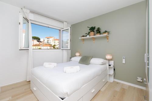 une chambre blanche avec un lit et une fenêtre dans l'établissement Immogroom - Warm T2 - AC - Wifi - Comfort, à Cannes