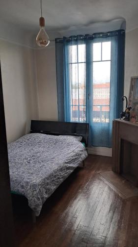 une chambre avec un lit et une fenêtre avec des rideaux bleus dans l'établissement Charmant f2 cosy proche paris, à Noisy-le-Sec