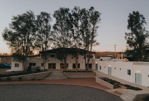 a white building with trees in the background at Casa Zamora in Villa de Juárez