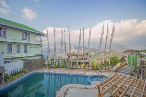 a swimming pool with chairs next to a house at Hotel O Demadzong in Gangtok