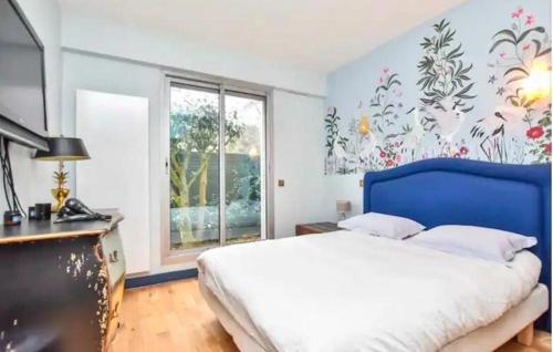 une chambre avec un lit bleu et une fenêtre dans l'établissement Place du Trocadero 25 mins away, à Boulogne-Billancourt