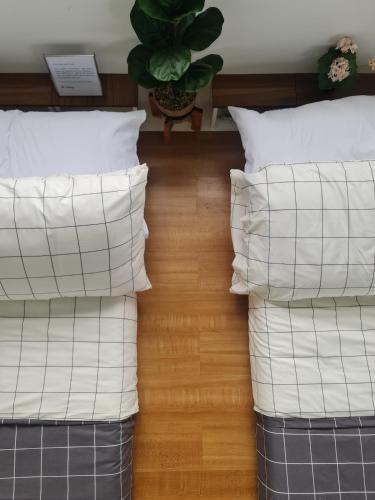 two stacks of pillows on a bed with a plant at The Zentuary - House with pool in Amadeo
