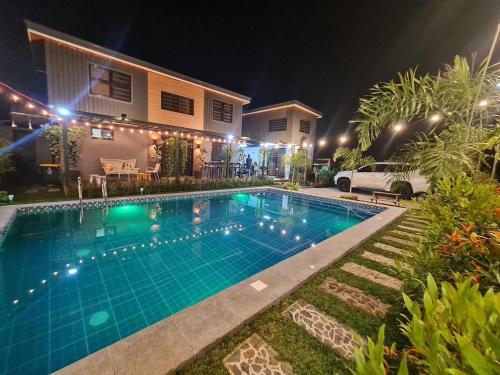 a swimming pool in front of a house at night at The Zentuary - House with pool in Amadeo