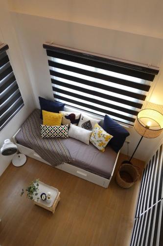 a room with a couch with pillows and a window at The Zentuary - House with pool in Amadeo