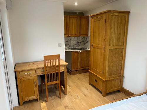 a kitchen with a wooden desk and a chair at Nikolay Lodge in Yate