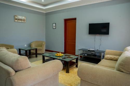 ein Wohnzimmer mit Sofas und einem Flachbildfernseher in der Unterkunft Downtown Oasis Suites in Lilongwe