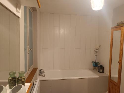 une salle de bain blanche avec une baignoire et un lavabo dans l'établissement Cozy house, à Arques-la-Bataille