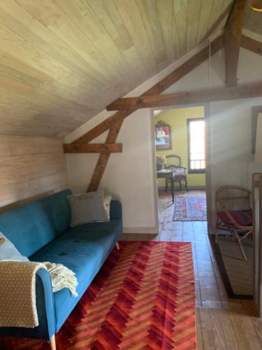 a blue couch in a living room with a wooden ceiling at Gîte La Louisiane in Salies-de-Béarn