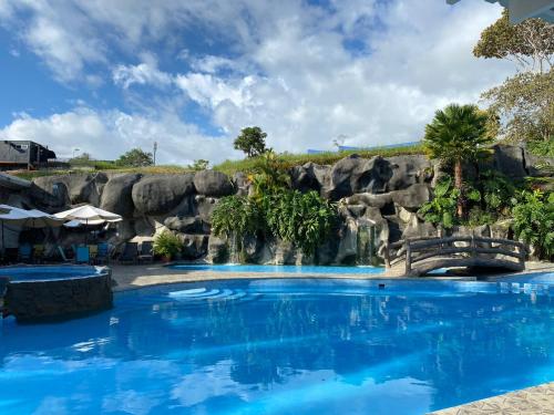 a pool at a resort with a rock wall at Hotel PZ Country Club & Conference Center in San Isidro
