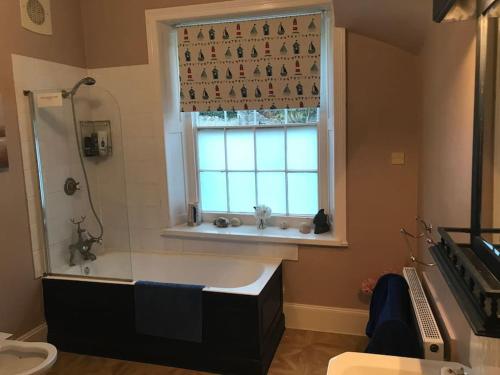 a bathroom with a bath tub and a window at Woodlands in Ventnor