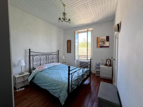 une chambre avec un lit avec une couette bleue et une fenêtre dans l'établissement Nice authentic house, à Ardes-sur-Couze