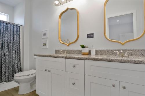 a bathroom with a sink and a toilet and mirrors at Spacious Beachfront 5BR with Gorgeous Ocean views - Blue Footed in Bolivar Peninsula