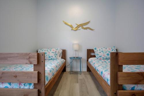 a bedroom with two bunk beds and a bird on the wall at Spacious Beachfront 5BR with Gorgeous Ocean views - Blue Footed in Bolivar Peninsula