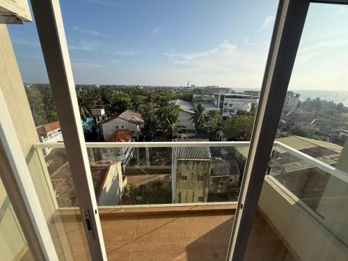 a view of a city from an open window at Negombo Ocean Breeze - ShoresEdge Luxury Apartments in Negombo