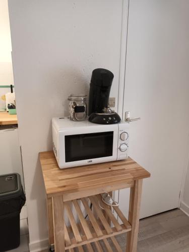 Un four micro-ondes est installé au-dessus d'une table en bois. dans l'établissement Studio 214 au cœur du Campus de Belle Beille, à Angers