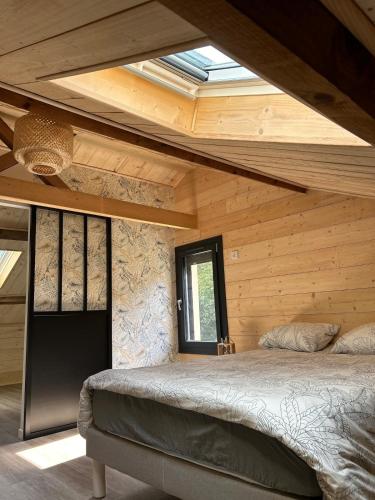 - une chambre avec un lit dans une maison en bois dans l'établissement Maison dans les bois, à Lacquy