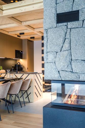 a fireplace in a dining room with a stone wall at Osada Maruszyna in Szaflary