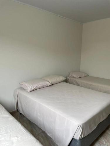 3 posti letto in una stanza con pareti bianche di Ike Palace 2 a Olímpia