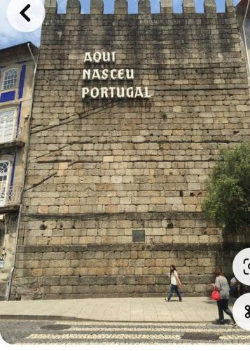 a large brick wall with a sign that reads not norwegian portal at Apartamento Centro Guimarães com Vista Panorâmica in Creixomil