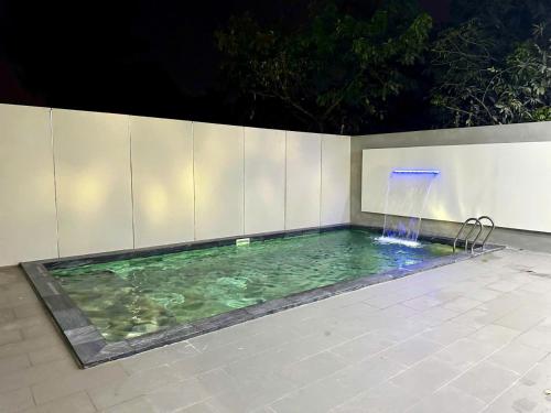 a swimming pool with a waterfall in a backyard at night at B-Villa Vung Tau in Vung Tau