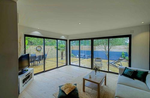 un salon avec un canapé et une télévision dans l'établissement La Teste De Buch - Maison 2 Chambres -, à La Teste-de-Buch