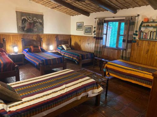 a room with four beds in a room at Finca los churquis in Tumbaya