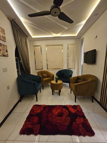a living room with couches and a ceiling fan at S H Residence & APARTMENTS in Mūsapur