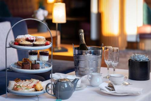 a table with a plate of food and a bottle of wine at Delta Hotels by Marriott Tudor Park Country Club in Maidstone