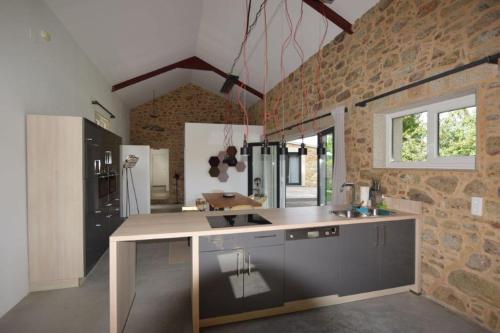 a kitchen with a counter and a brick wall at Casa La Pedrosa - Tedin in Cee